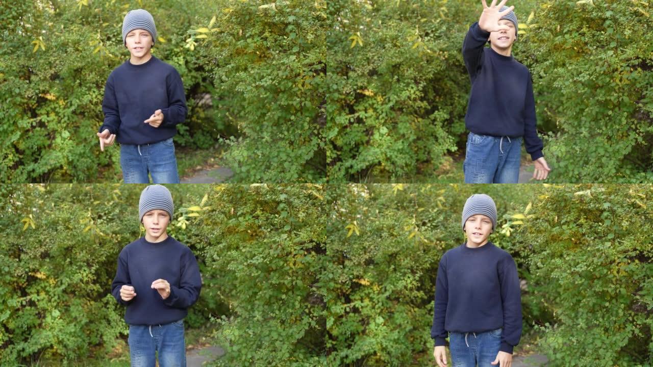 儿童博客作者在公园录制他的视频vlog。男孩在户外秋天在他的博客频道的摄像机前讲话。小影响者激励追随