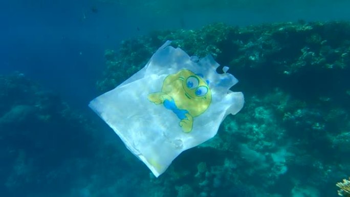 塑料购物袋在美丽的珊瑚礁附近漂流，周围有热带鱼。塑料垃圾环境污染问题。(4K-60fps)