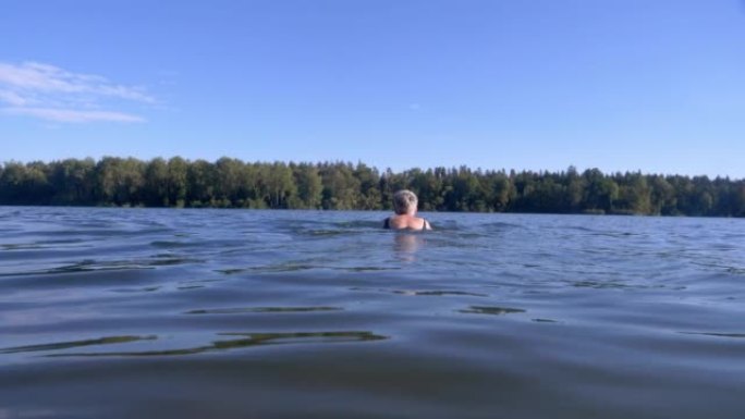 在湖中游泳的高级女子