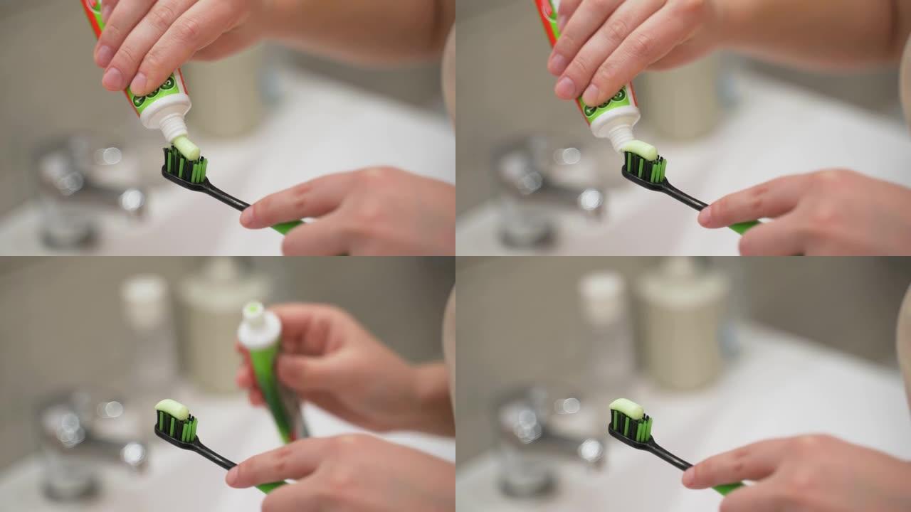 用手从黑色和绿色牙刷上的浴室水槽上的管子上挤压绿色牙膏。准备刷牙。牙科护理，习惯，日常生活