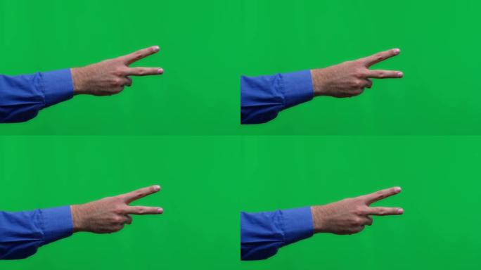 人的手在绿色背景上隔离，人显示两个手指。