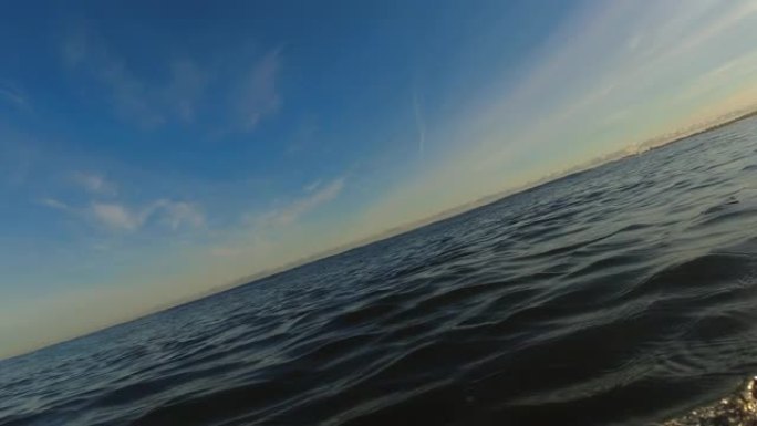 冲浪者在日出时在波罗的海海浪上划水POV慢动作