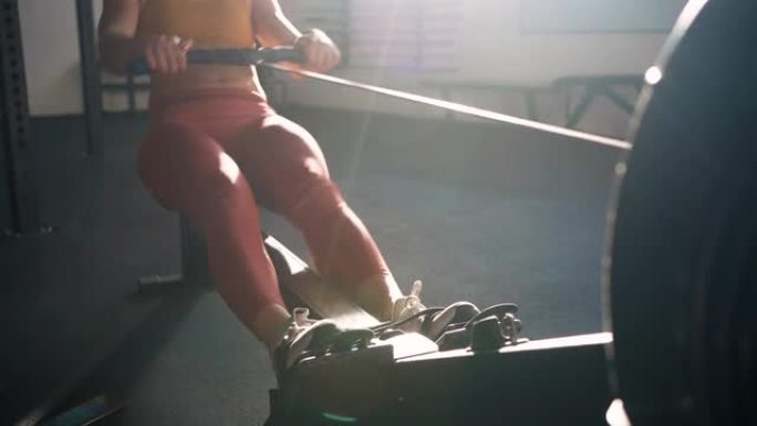 高加索女运动员在健身房的划船机上锻炼