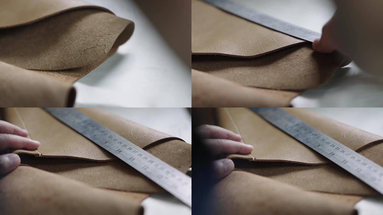 艺术家的手用尺子测量皮革作品。