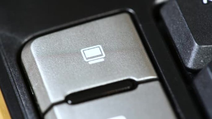 手指按下电脑显示器符号快捷键宏激活键，现代办公键盘上的按钮，对象细节，极端特写。台式电脑图标，硬件，