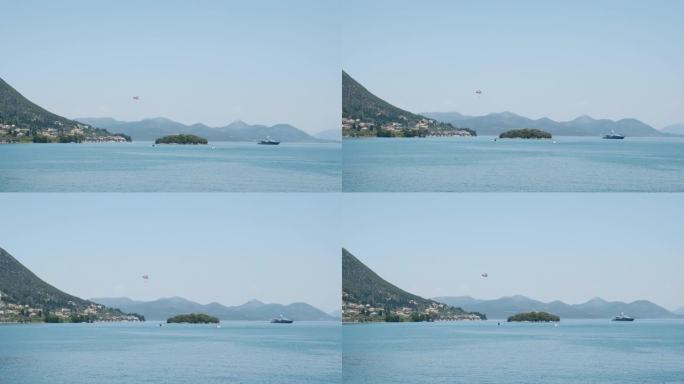 地中海岛屿景观。快艇，游客在船后降落伞上