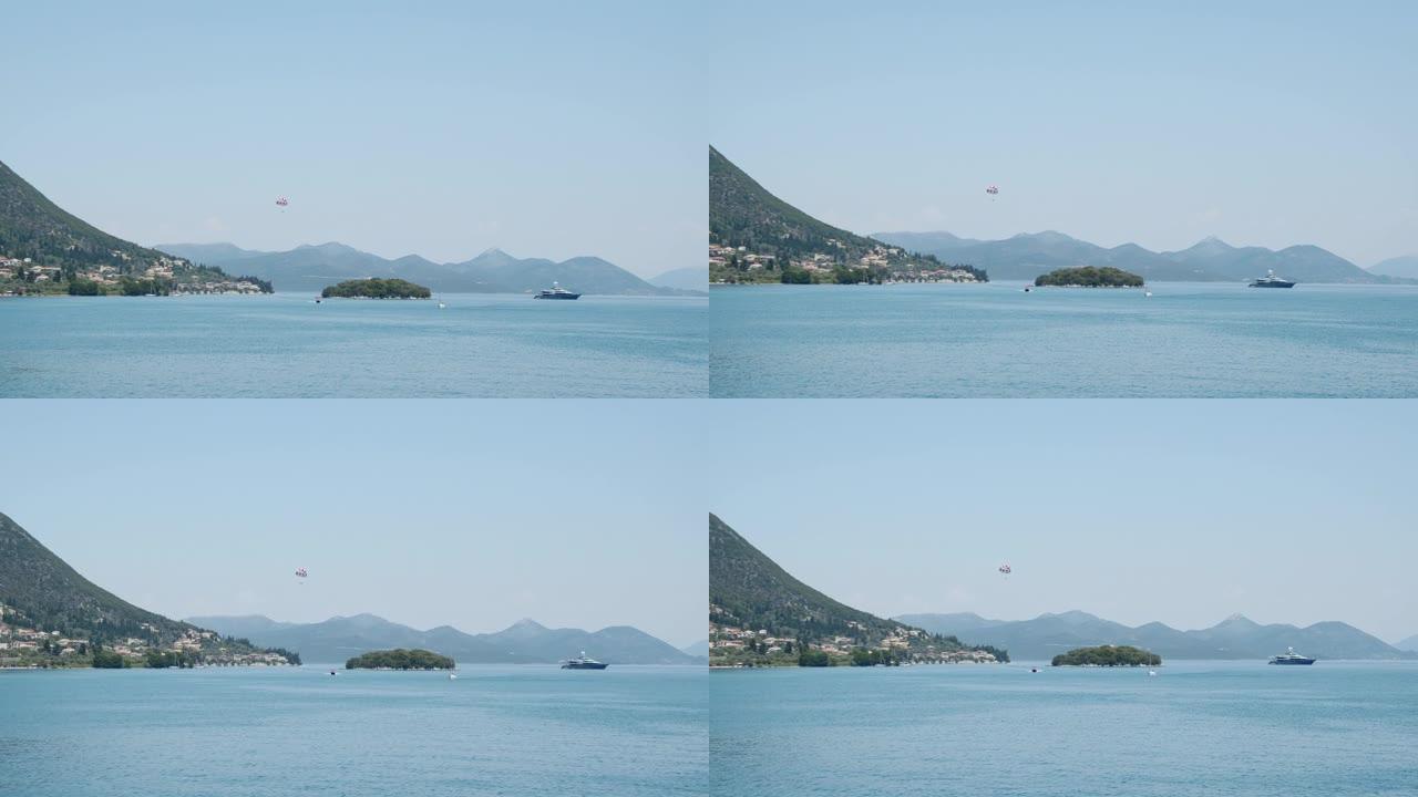 地中海岛屿景观。快艇，游客在船后降落伞上