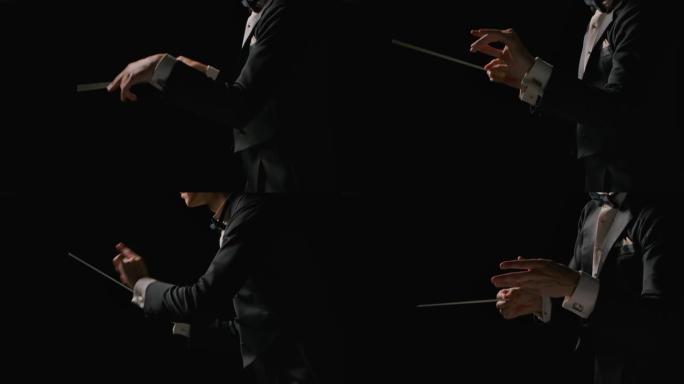 身穿西装的交响乐团指挥正在指挥指挥棒运动的音乐家，这些指挥棒孤立在黑色背景上。指挥，用可见的手势指挥
