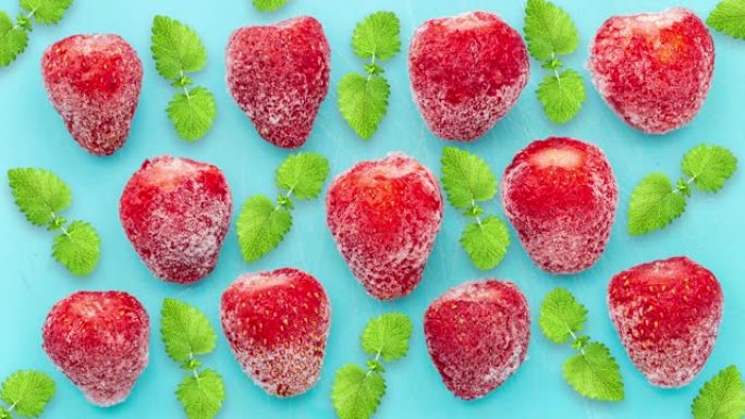 清爽莫吉托、柠檬水和冰沙的配料。冷冻草莓和薄荷在蓝色背景上解冻。冬天的水果和浆果。冷冻食品特写。新鲜