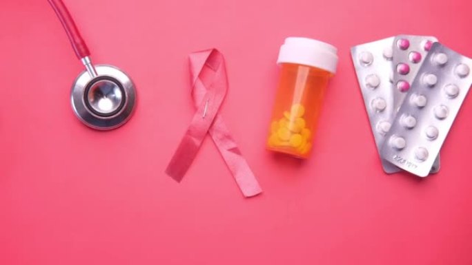 红丝带HIV，听诊器，红色背景的药片。