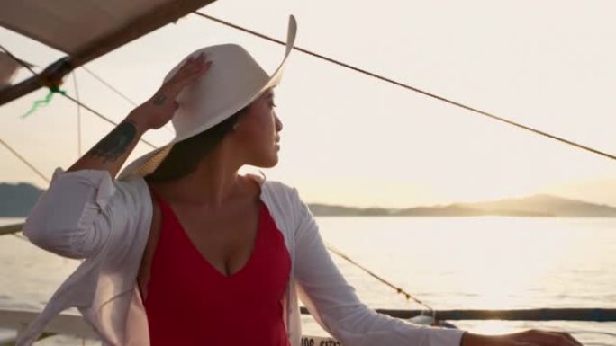 戴着太阳帽在支腿船上放松的女人