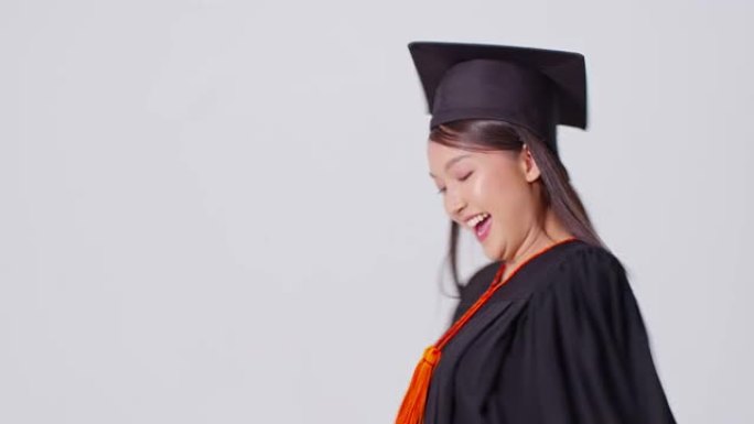 美丽迷人的亚洲女人毕业于帽子和礼服微笑如此自豪和幸福，孤立在白色背景，教育成功理念