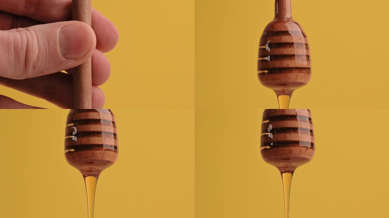 健康食品概念。美味的甜蜜糖液体蜂蜜从黄色背景上的木勺流下来。有机健康蜂蜜，维生素，甜食。从勺子里滴下