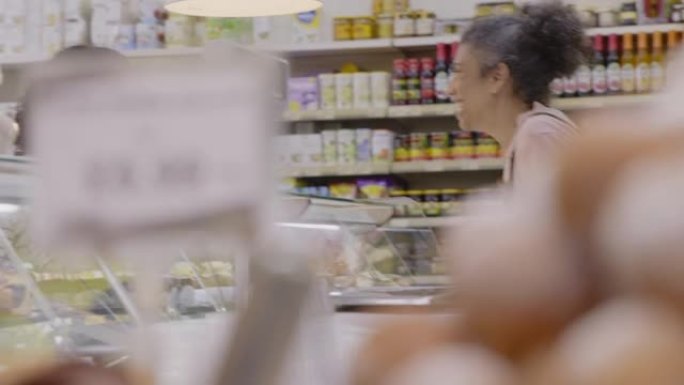 女工在超市的展示柜中帮助顾客