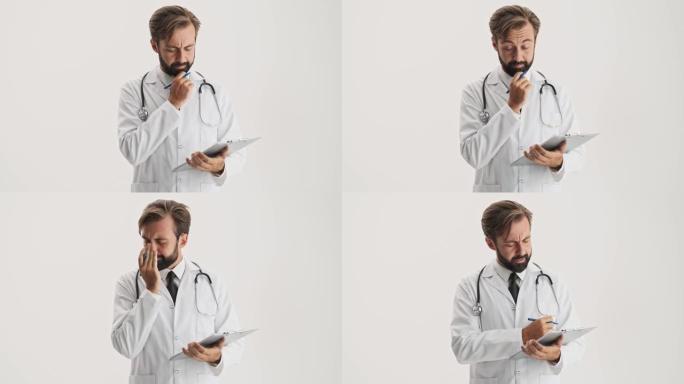 令人失望的体贴的男人医生，听诊器在专心处理文件时触摸胡须和鼻梁