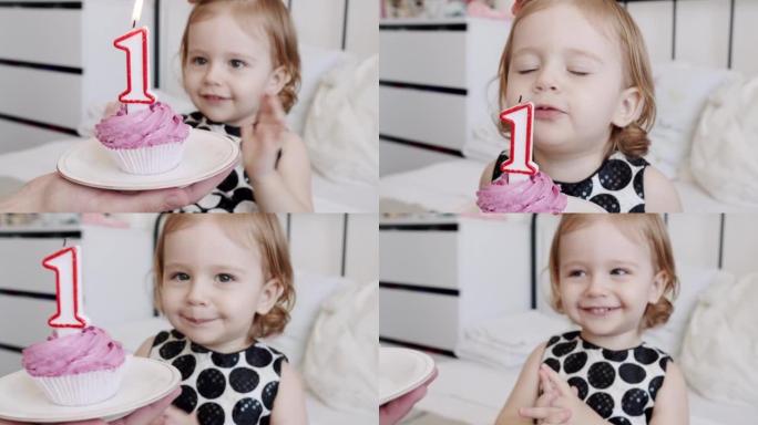 一个快乐可爱的1岁女孩的生日聚会，并在蛋糕上吹蜡烛。
