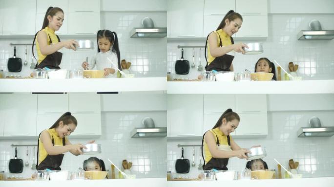 年轻的母亲与女儿在厨房里度过时光，为饼干做面团