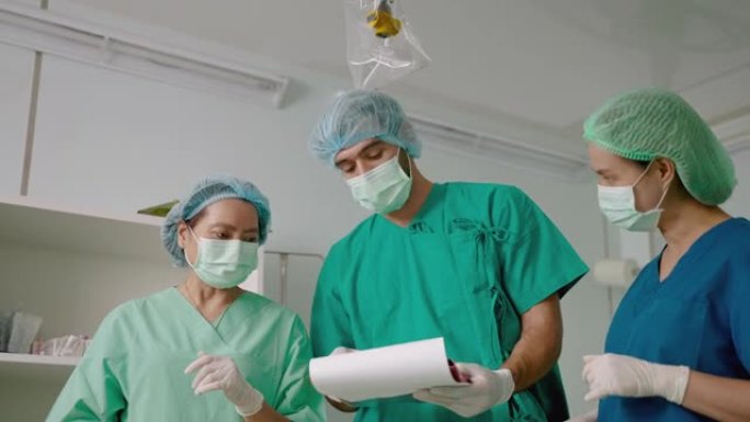 手术室的医生和护士团队正在从患者的病史文件中咨询患者的病情。