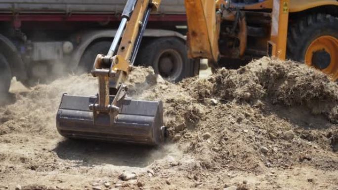 工业挖掘机将高速公路施工现场的土壤材料装载到自卸车中，慢动作