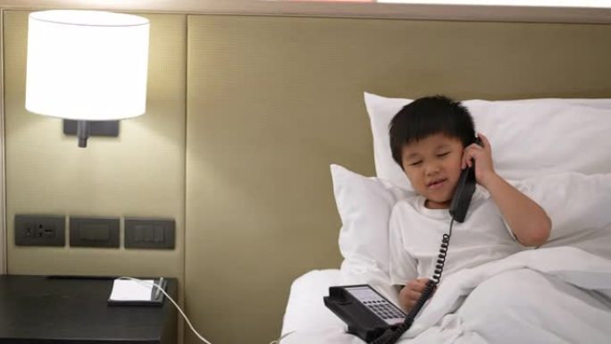 亚洲男孩打电话到酒店接待处。接待和客户服务的概念