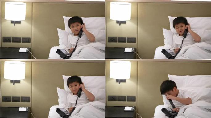 亚洲男孩打电话到酒店接待处。接待和客户服务的概念