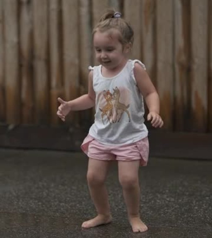 雨天在街上玩耍的小女孩