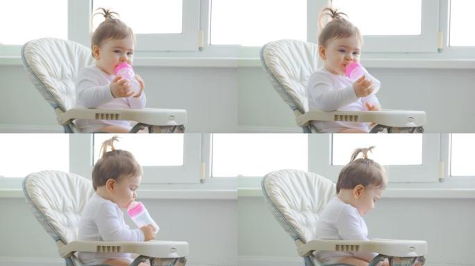 可爱的女婴在房子窗户附近玩塑料勺子。