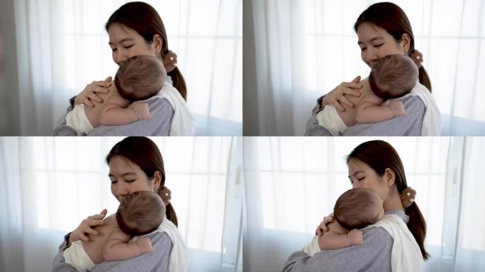 4K 25fps慢动作，母亲抱着婴儿并揉了揉头，使她在温暖的怀抱中入睡。