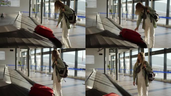 在机场等候行李旁边的旅行妇女，在传送带上检查箱子