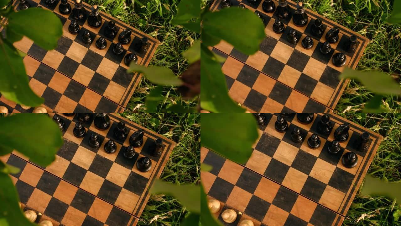 草地上花园里的一个古老的棋盘，上面有象棋。国际象棋锦标赛。学会下棋，赢球。智力运动