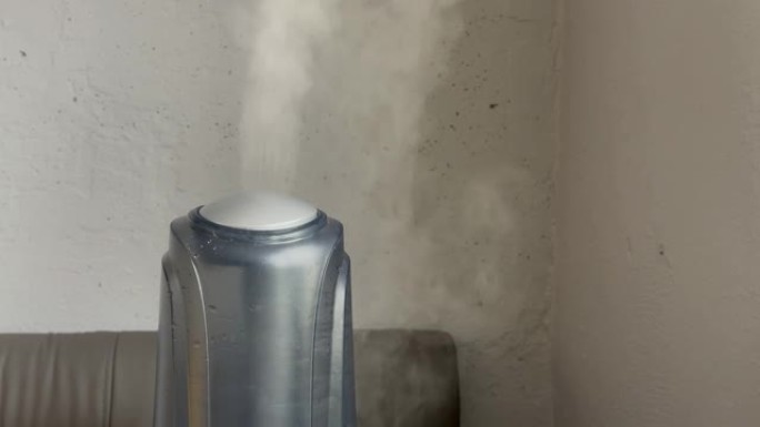 加湿器在高功率下工作，然后在灰色墙壁背景上关闭。来自加湿器的水雾蒸汽。