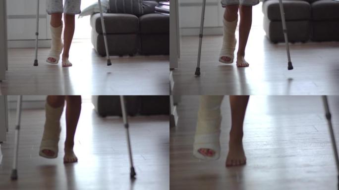 用石膏石膏折断腿的年轻女子试图在客厅用拐杖走路。身体伤害、骨折和事故，