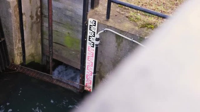 水快速流过控制门锁，水位计板秤附着在混凝土运河岸