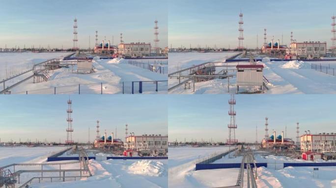 冬天，一架无人机飞过一家石油和天然气精炼厂。在西伯利亚的雪中飞越管道。俄罗斯的石油和天然气生产。对俄
