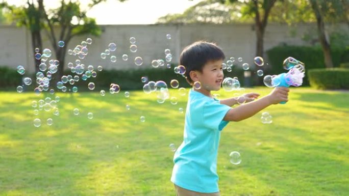 亚洲孩子在公园玩泡泡。幸福与夏天的概念