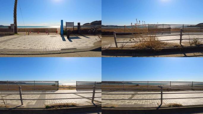 海边有阳光的路。海岸线上可以看到海洋的人行道。海滩上的人