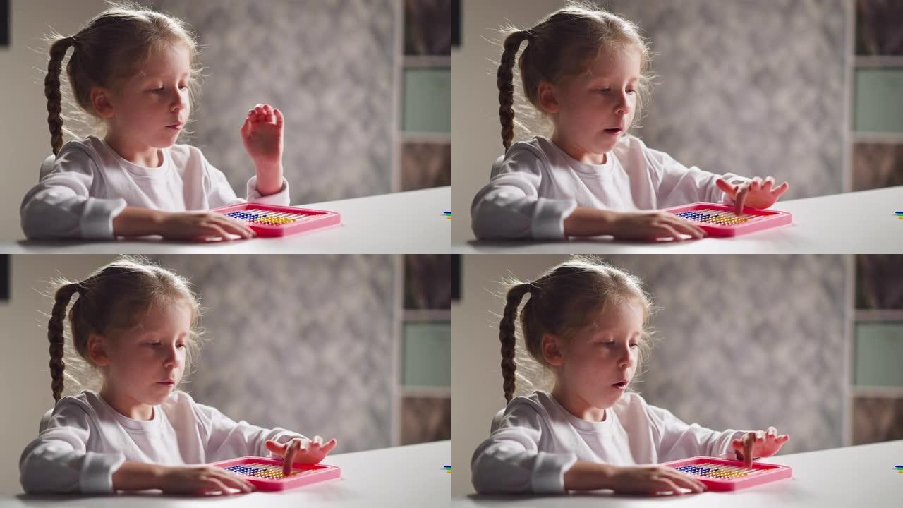 受启发的小女孩学会在桌子上用玩具算盘计数