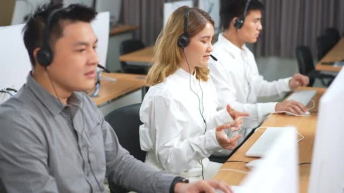 亚洲呼叫中心团队，客户服务，带耳机或耳机的电话销售在现代办公室与客户交谈