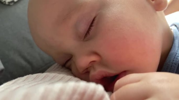 熟睡的婴儿脸部特写肖像闭着眼睛张开嘴巴粉红色的脸颊