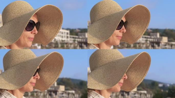 海边戴着帽子的微笑女人的脸。