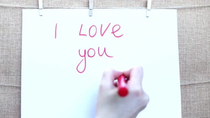 女人的手在一张带有红色记号笔的白纸上画出红色的心。