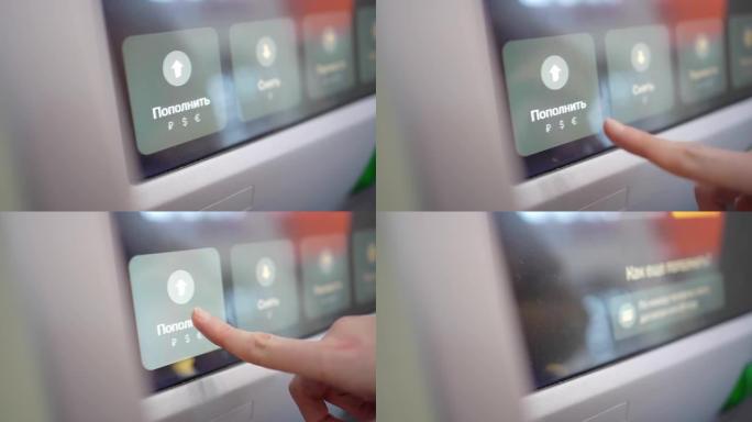 妇女的手将俄语的充值按钮放在atm屏幕上。