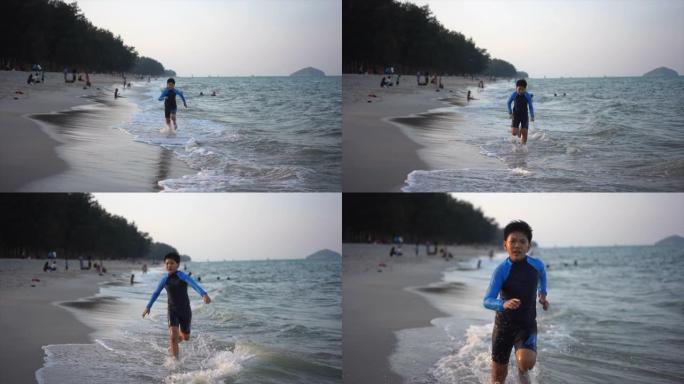 亚洲男孩在海滩上享受和玩海和沙子的慢动作镜头