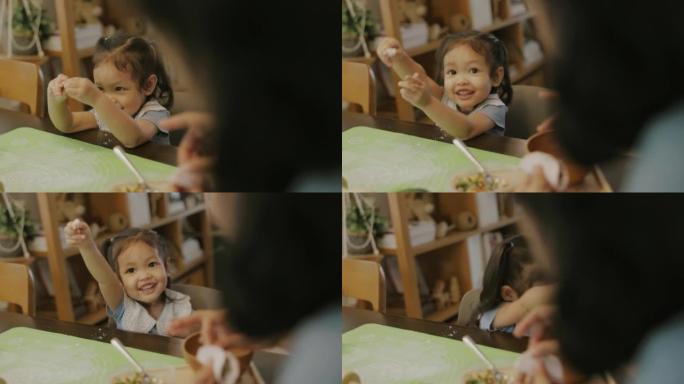 可爱的亚洲女孩快乐，同时喜欢帮妈妈做自制饺子。