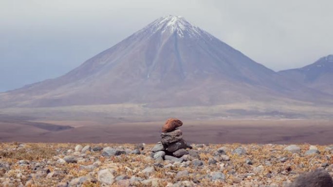 火山峰背景上石棺形状的石头堆