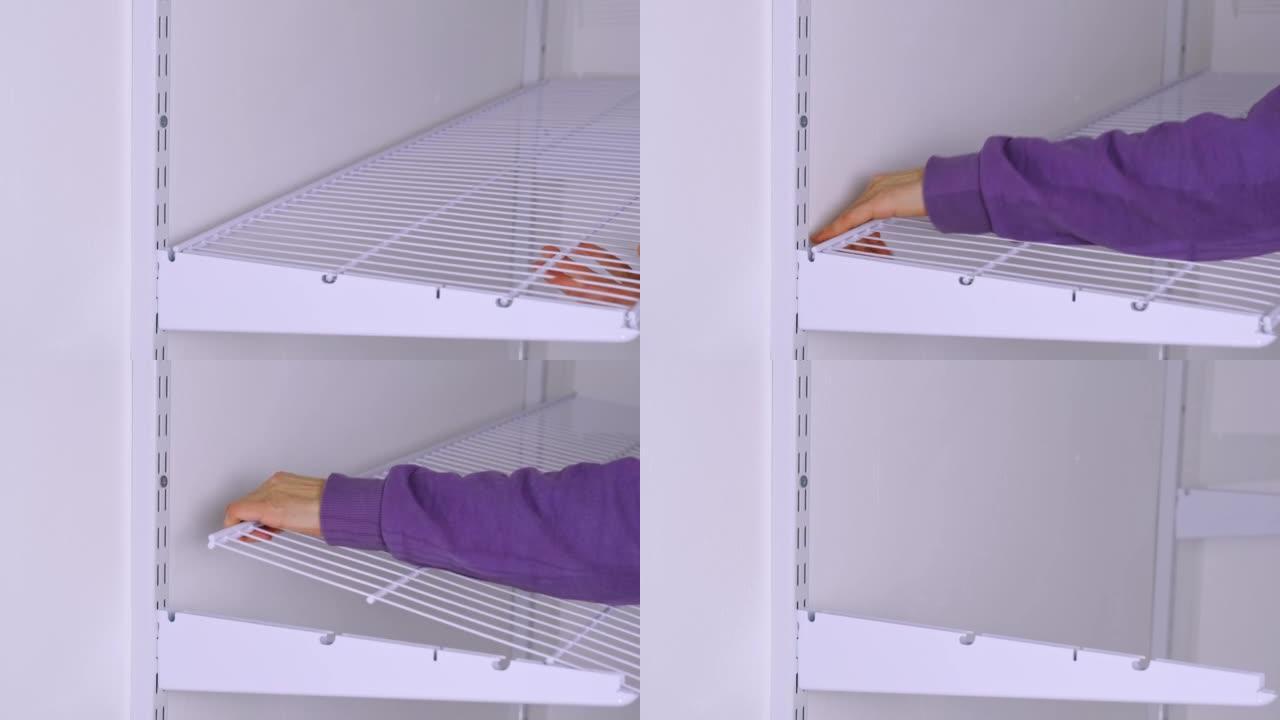 将金属网架安装在更衣室系统中的支架上。一个穿着紫色连帽衫的女人正在组装一个白色存储系统