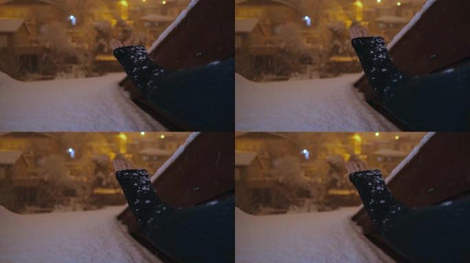 女人的手试图在晚上摔倒时抱雪