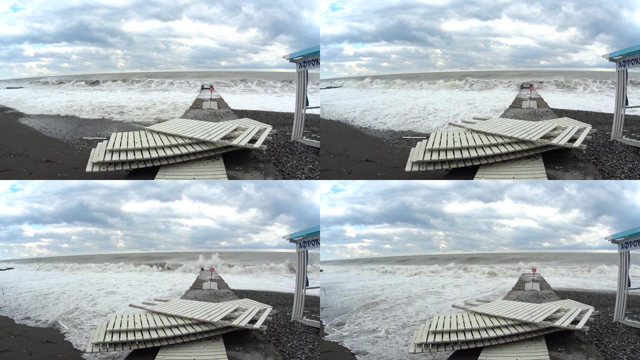 海滩上的暴风雨。散落的栅栏，巨大的海浪将一切都冲入大海