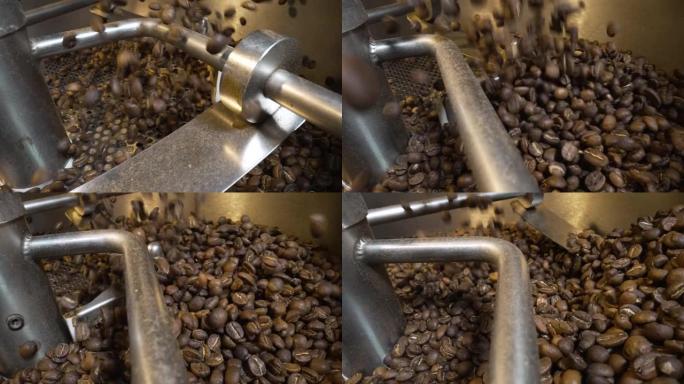 将咖啡豆倒入工厂的工业咖啡烘焙机中。混合烘焙咖啡豆。芳香棕豆旋转特写。咖啡馆的餐饮背景。慢动作