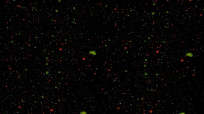 黑色背景上的圆形五彩球，银色亮片。红色和绿色颗粒随机移动。